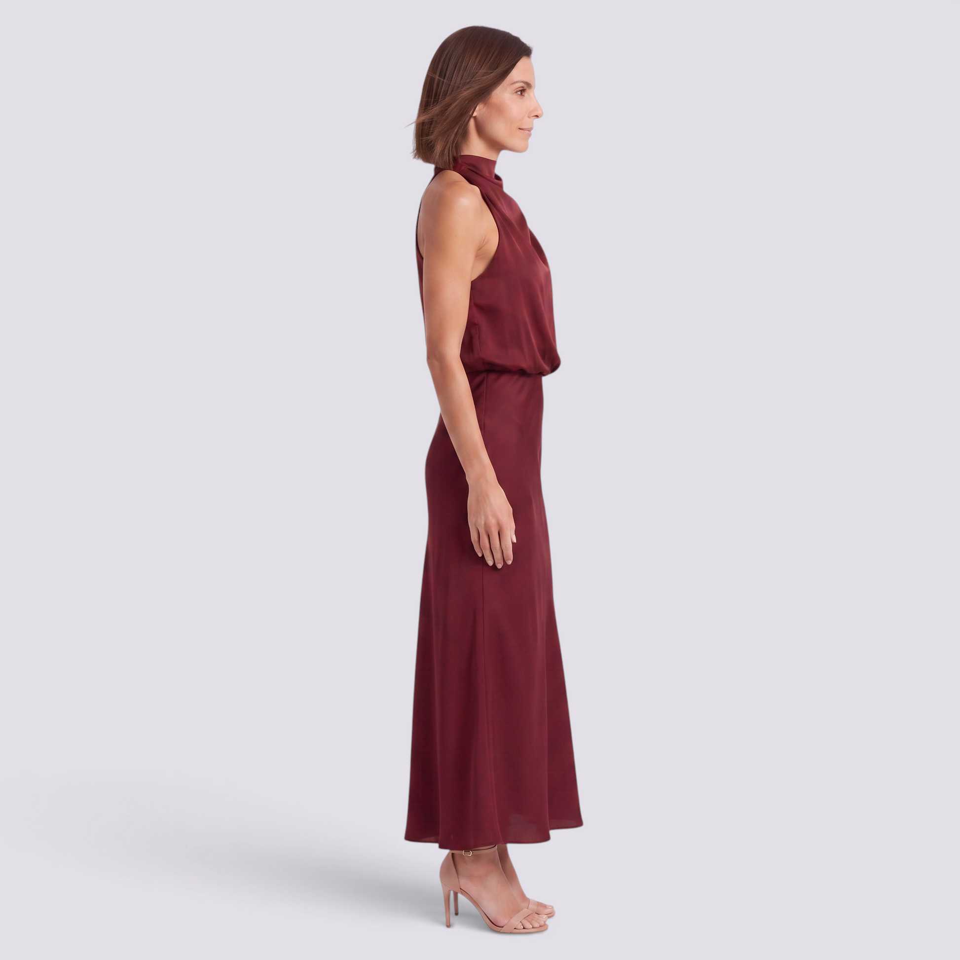 Essyro burgundy satin halter neck maxi dress with draped bodice and open back worn by a woman in profile view