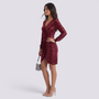 Essyro burgundy sequin party dress with long sleeves, V-neck, and waist draping worn by a model with heels.