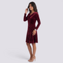 Essyro burgundy velvet short dress with a draped cowl neck and long sleeves worn by a smiling model.