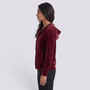 Essyro burgundy velvet hooded cardigan with front buttons and pockets worn by a model in profile view