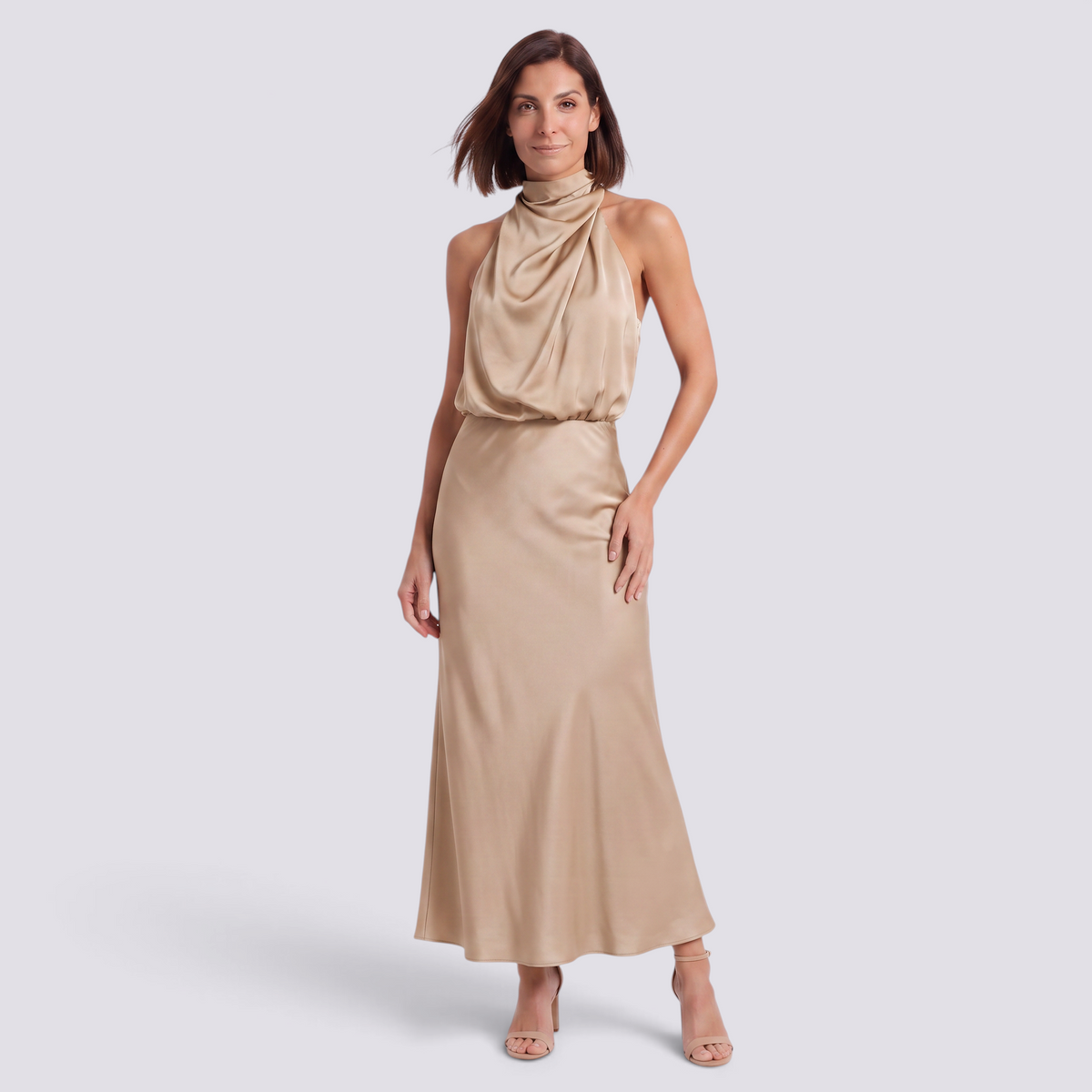 Essyro champagne satin halter neck maxi dress with draped bodice and flowing bias-cut skirt on a woman