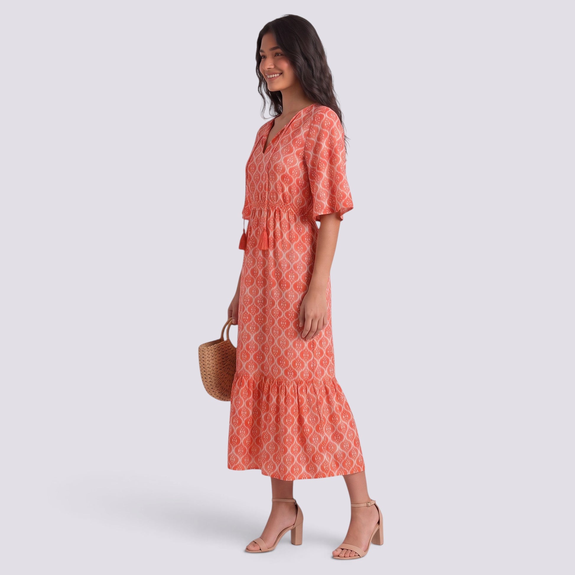 Essyro bohemian long dress in coral with white geometric print, V-neck, short sleeves, and a flowing tiered skirt.