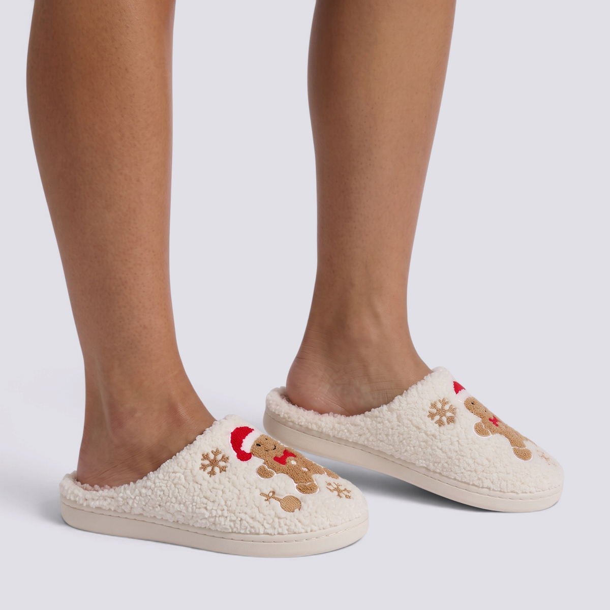 Essyro cream sherpa slippers featuring embroidered gingerbread men with Santa hats and snowflakes for Christmas