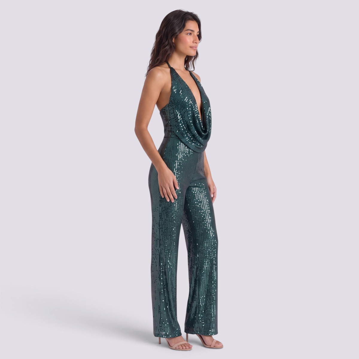 Essyro emerald green sequin jumpsuit with a draped halter neckline and wide-leg trousers worn by a model