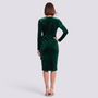 Back view of a woman wearing an Essyro emerald green velvet cocktail dress with long sleeves and a fitted silhouette.