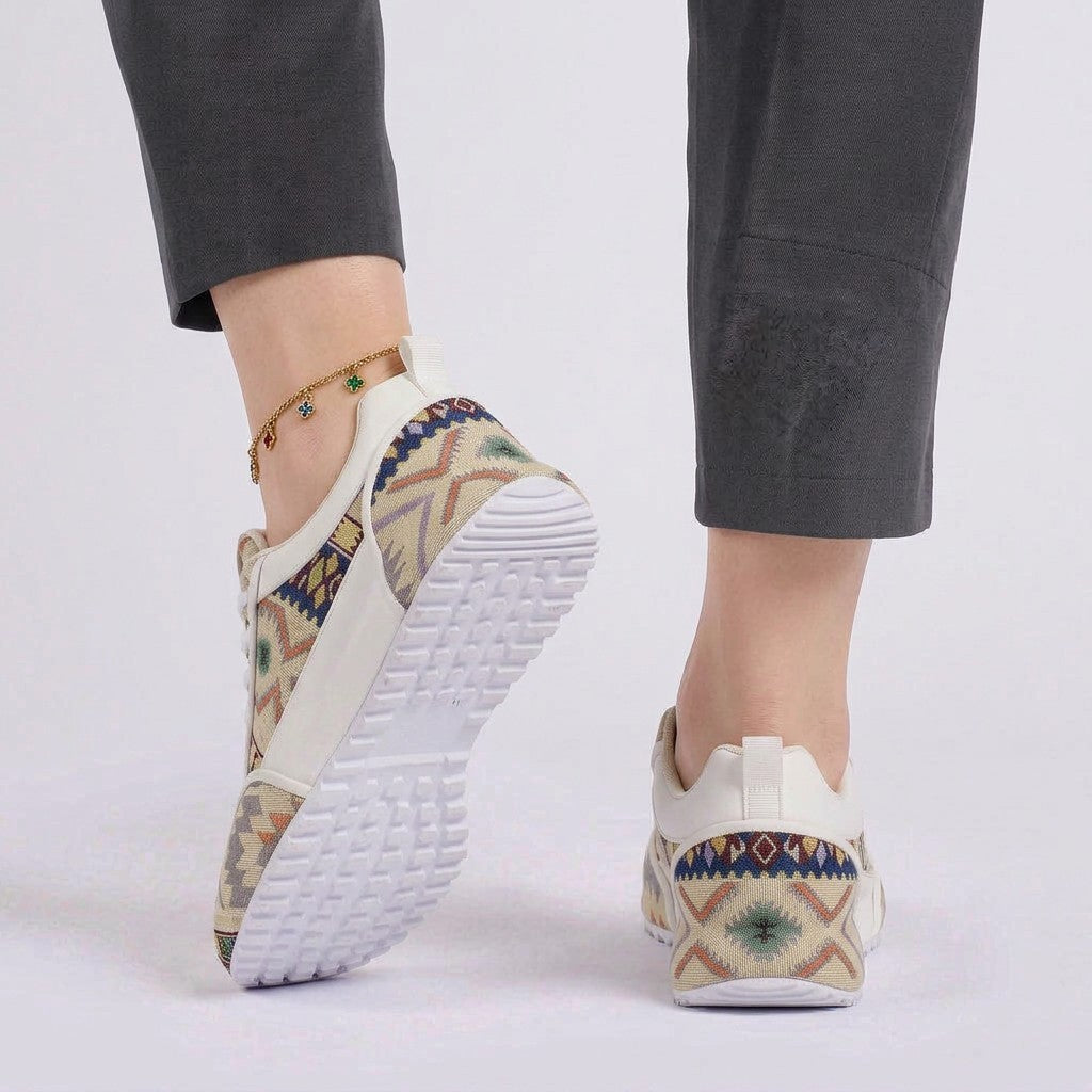 Essyro chunky dad shoes featuring a woven ethnic pattern in multi-color tones, worn with grey trousers.