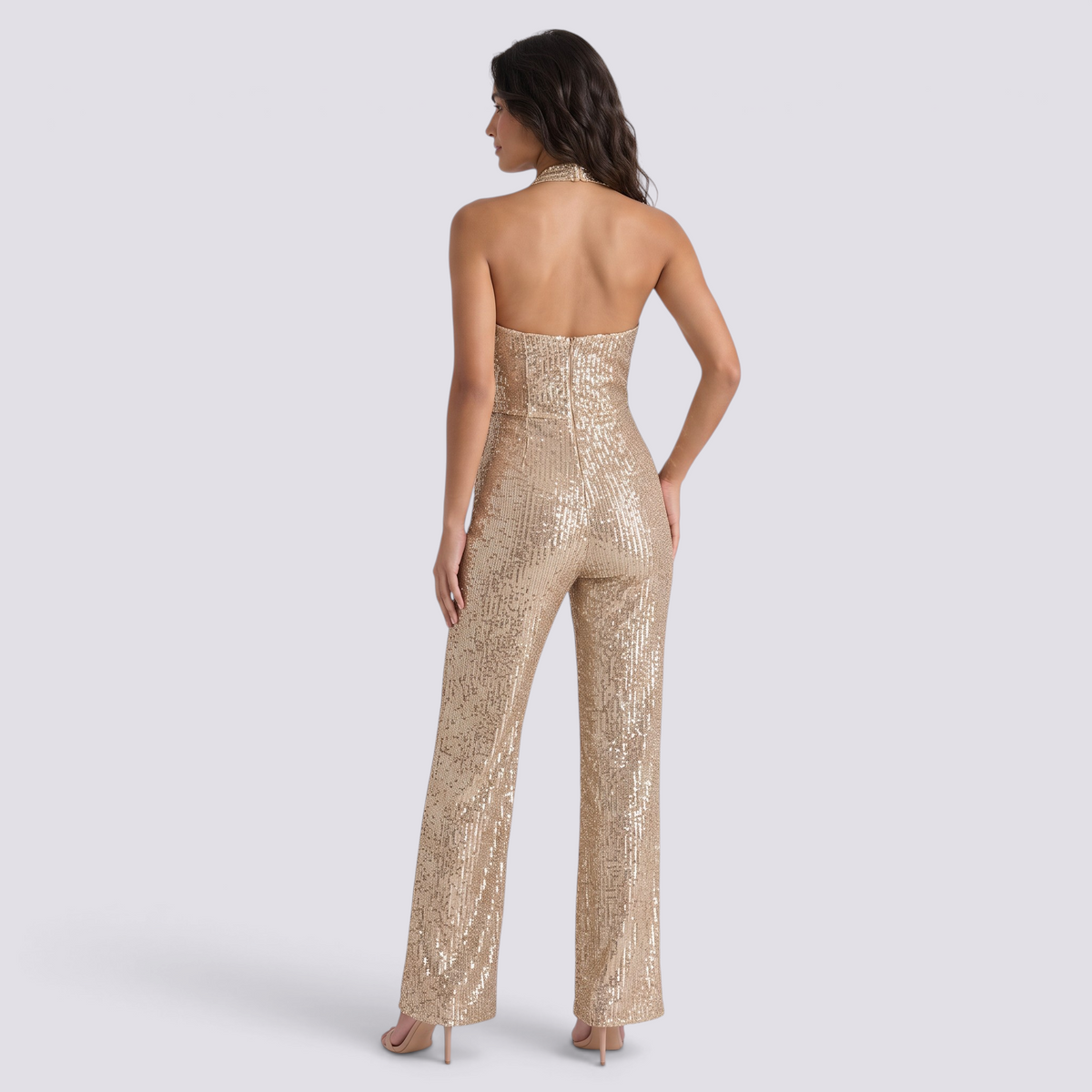 Essyro gold sequin halter neck jumpsuit with wide legs and open back worn by a model on a white background