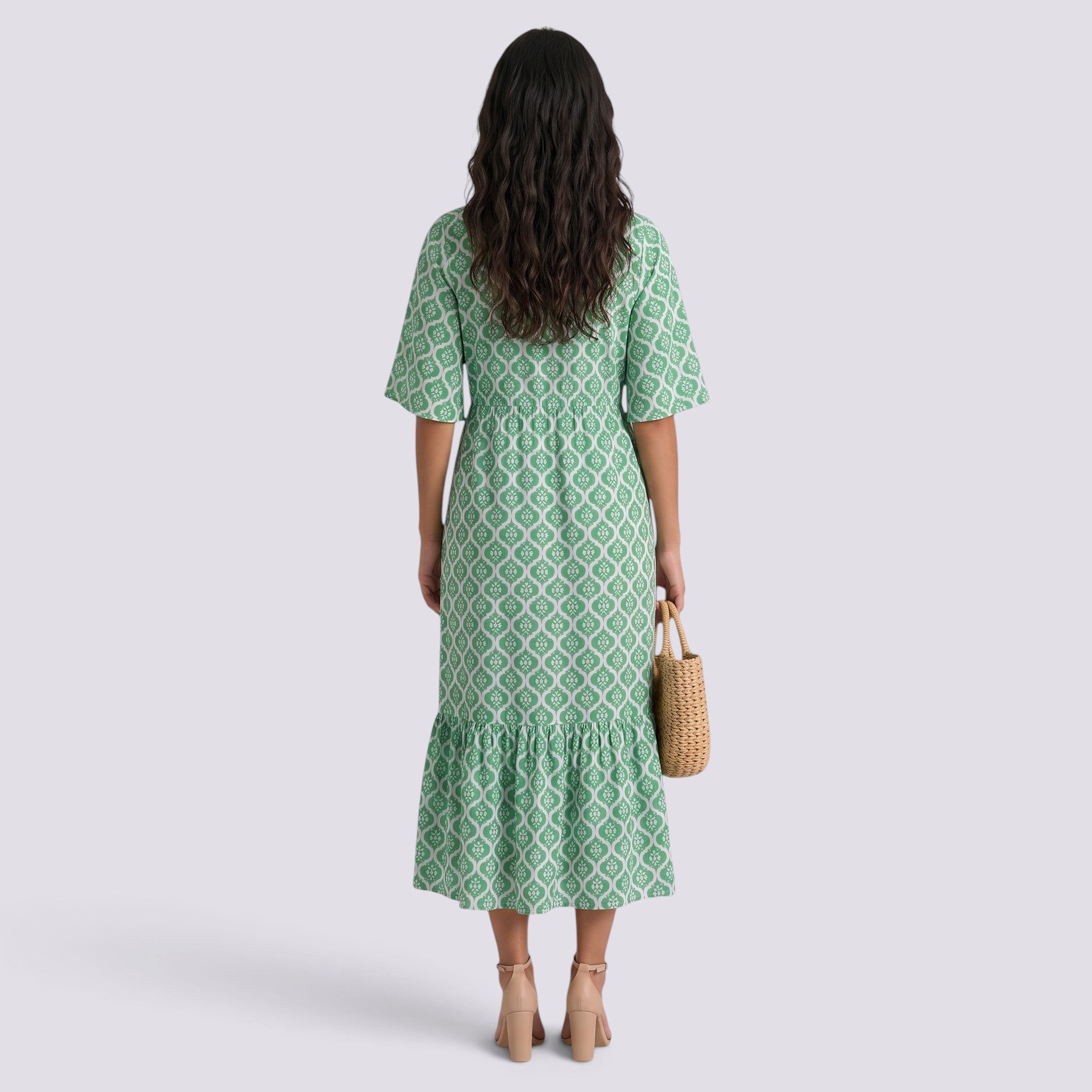 Back view of a woman wearing an Essyro green bohemian maxi dress with a geometric pattern and short sleeves.