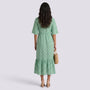 Back view of a woman wearing an Essyro green bohemian maxi dress with a geometric pattern and short sleeves.