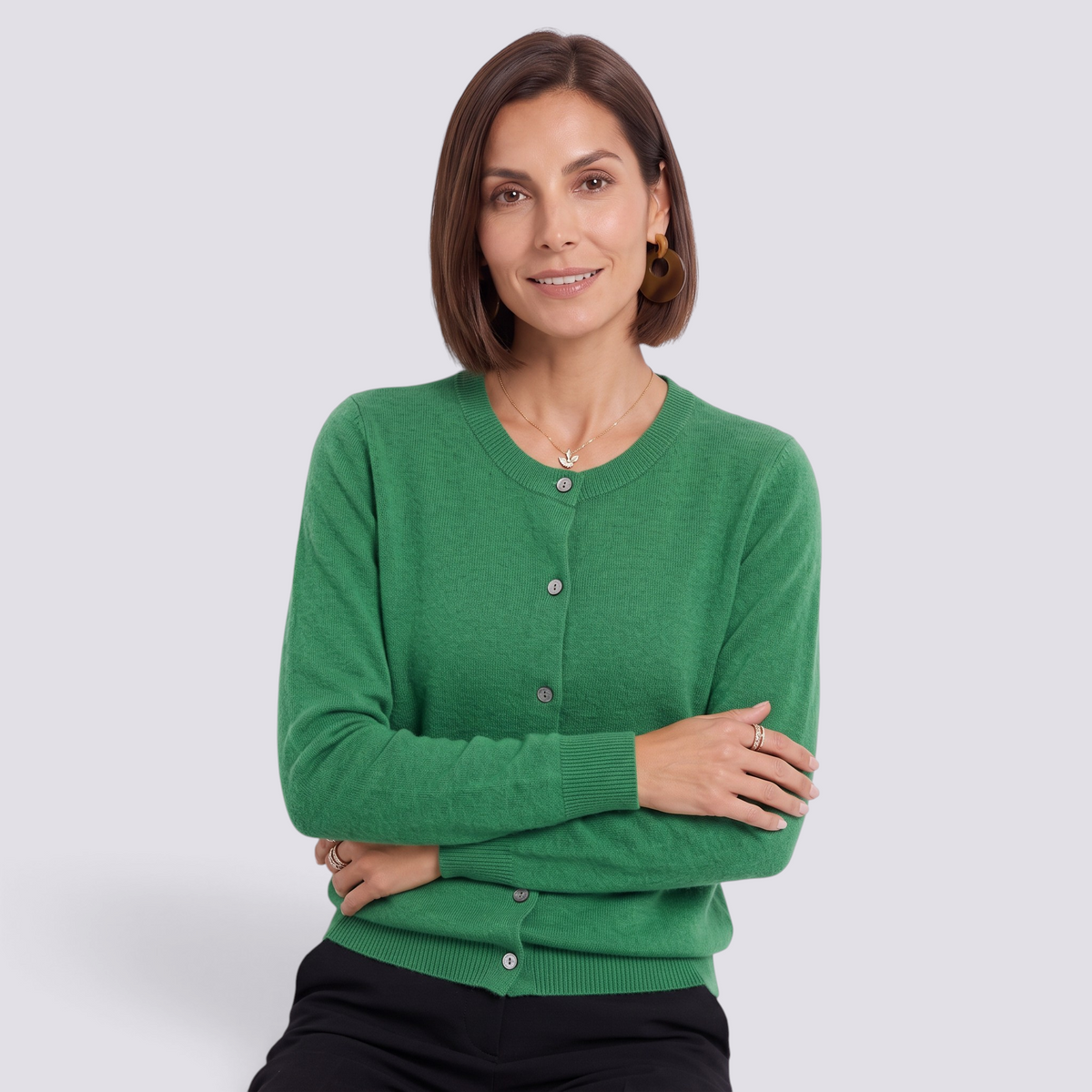 Essyro green crew neck knit cardigan with button front, long sleeves, and ribbed cuffs worn by a smiling woman