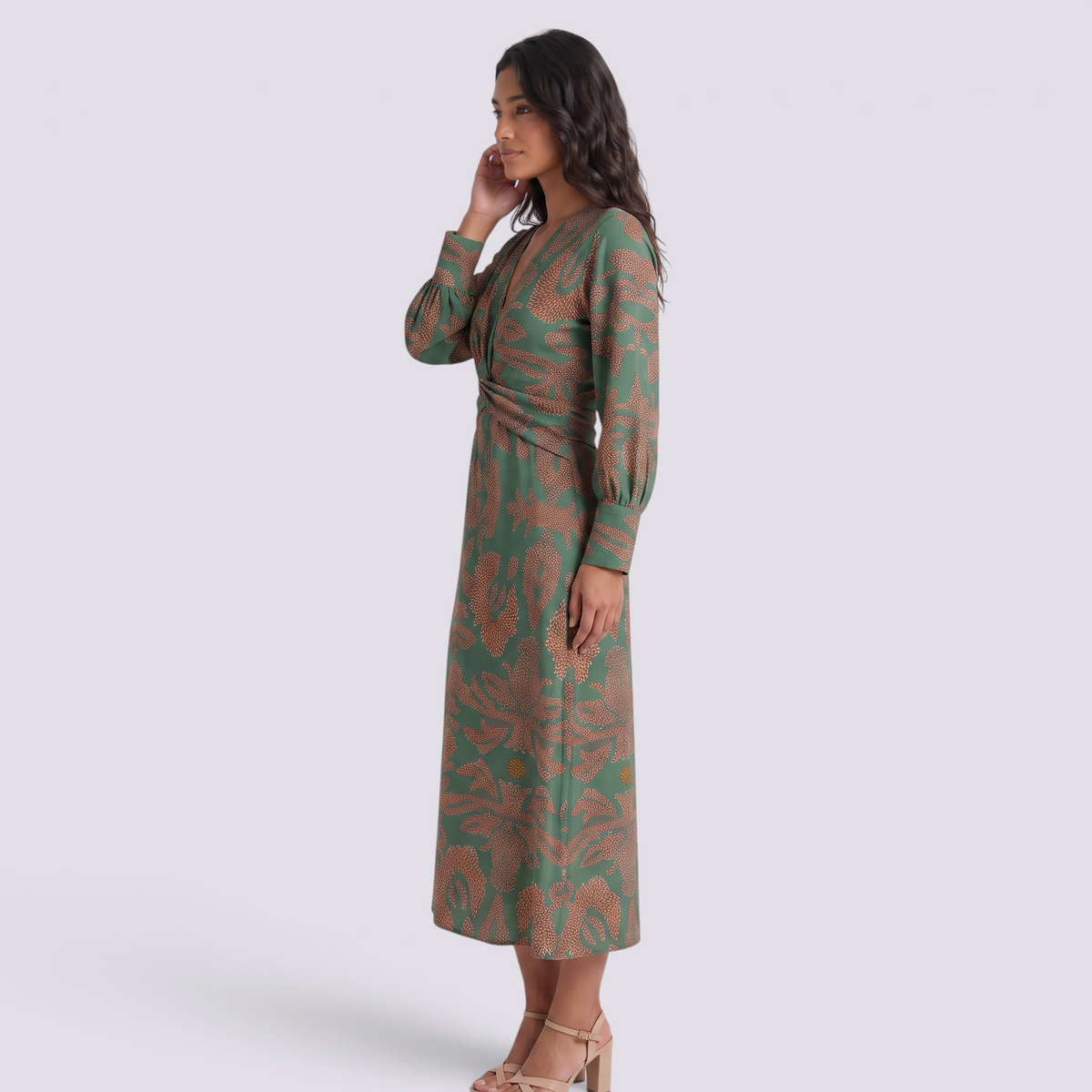 Essyro midi A-line dress in green with artistic print, V-neck, and 3/4 sleeves worn by a model, side profile view.
