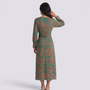 Back view of a woman wearing an Essyro green midi dress with a contemporary artistic print and 3/4 sleeves.