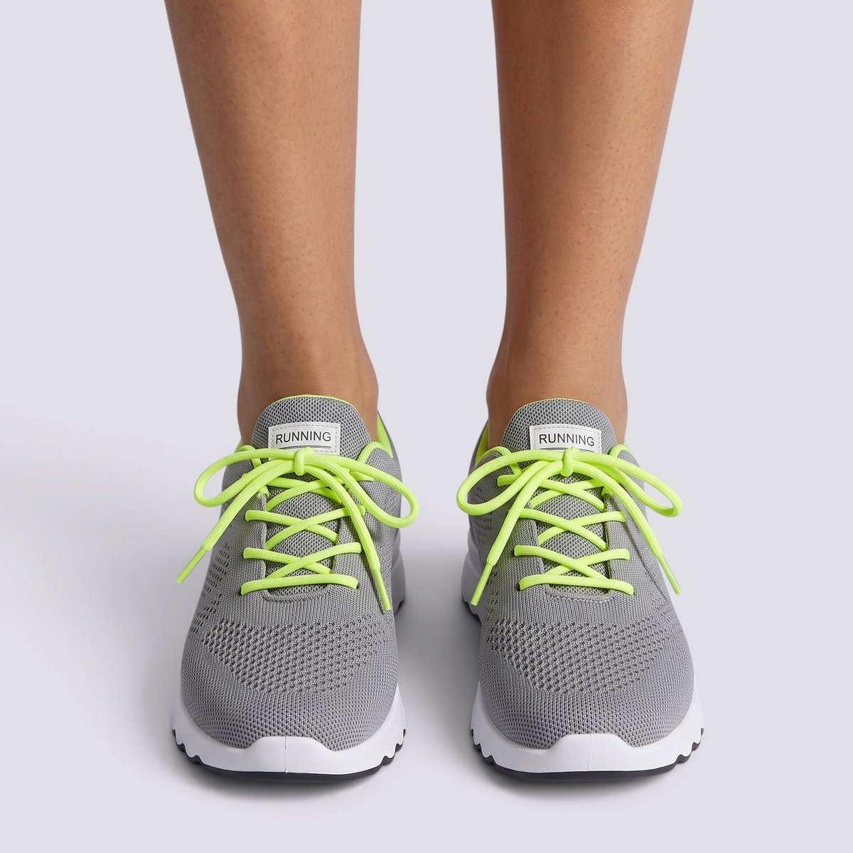 Essyro women's lightweight grey sneakers with breathable knit fabric, neon yellow laces, and a flexible white sole.