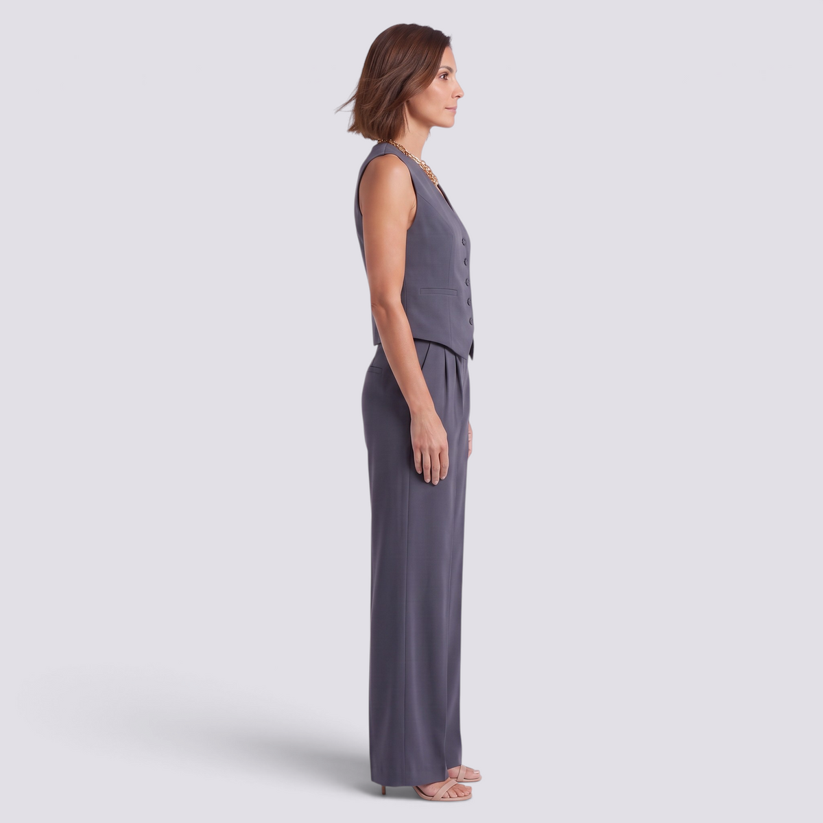Essyro tailored vest and high-waisted palazzo pants set in grey, worn by a woman in a side profile view.