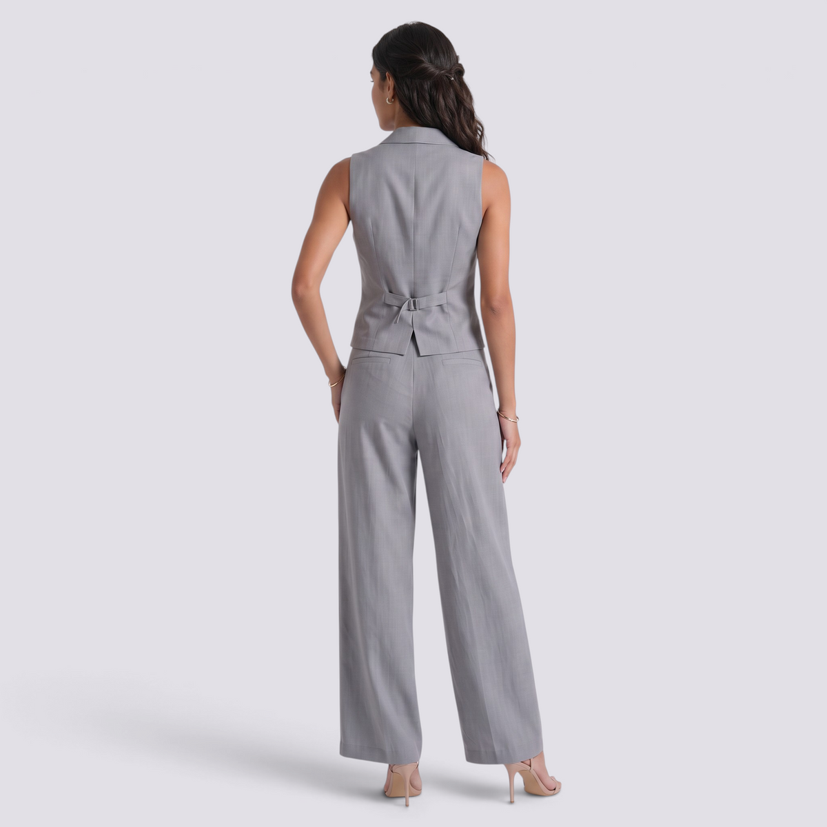 Back view of a woman wearing an Essyro grey tailored vest and matching wide-leg trousers for a sophisticated look.