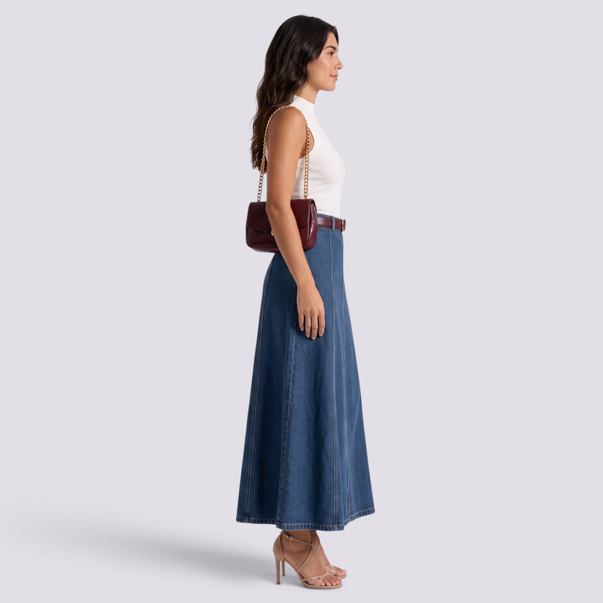 Model wearing an Essyro high-waisted maxi denim skirt with vertical panels and contrast stitching, side view.