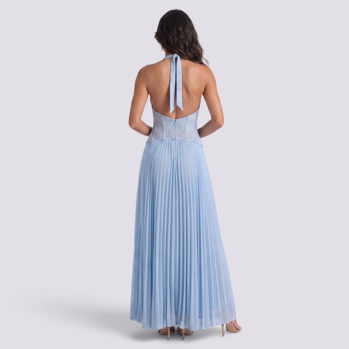 Essyro light blue floor-length pleated gown with a corset bodice and open back, worn by a model from behind.