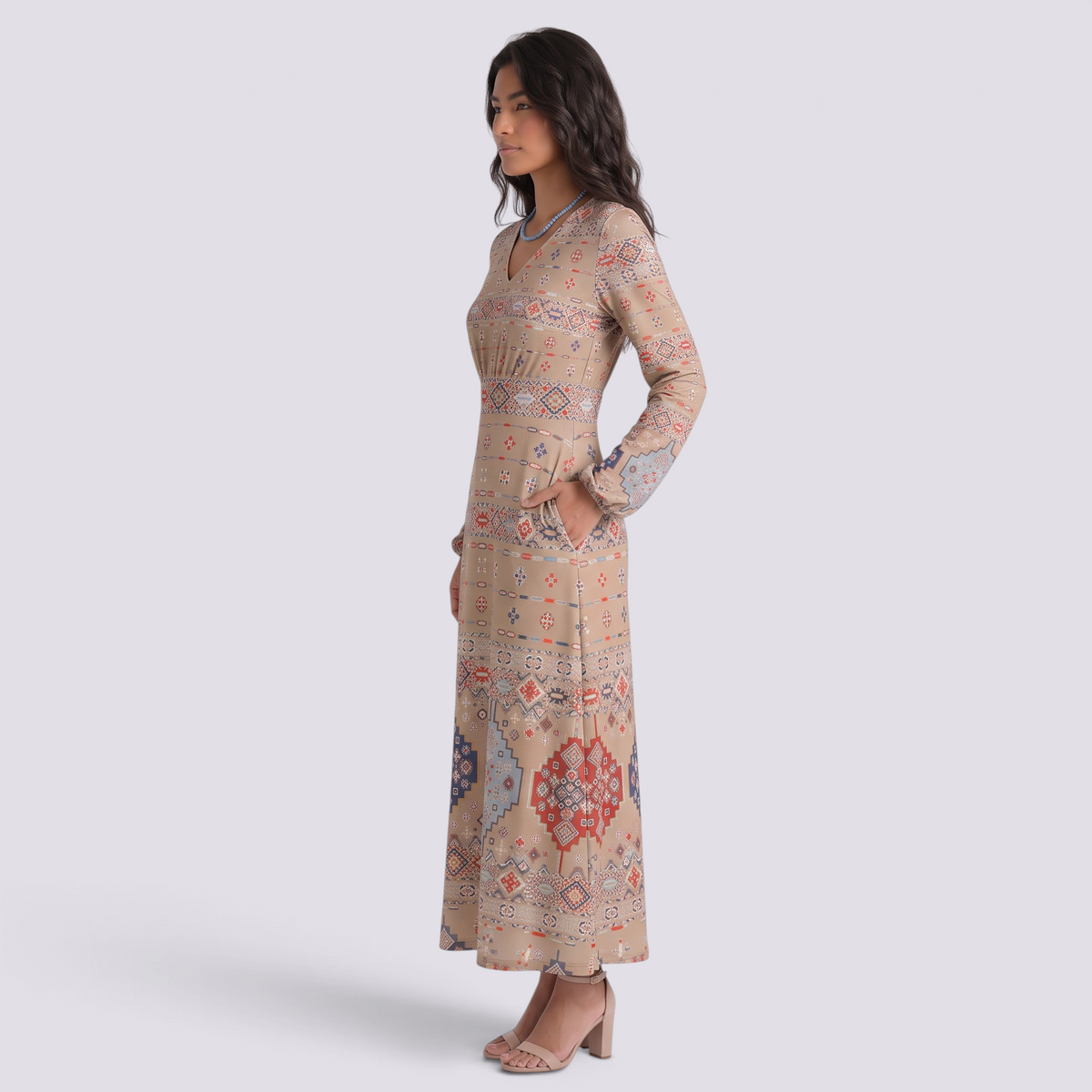 Essyro long beige dress with V-neck, long sleeves, and geometric print, worn by a model in a studio setting.