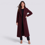 Essyro long burgundy coat with wide lapels worn by a model over a black outfit against a neutral studio background