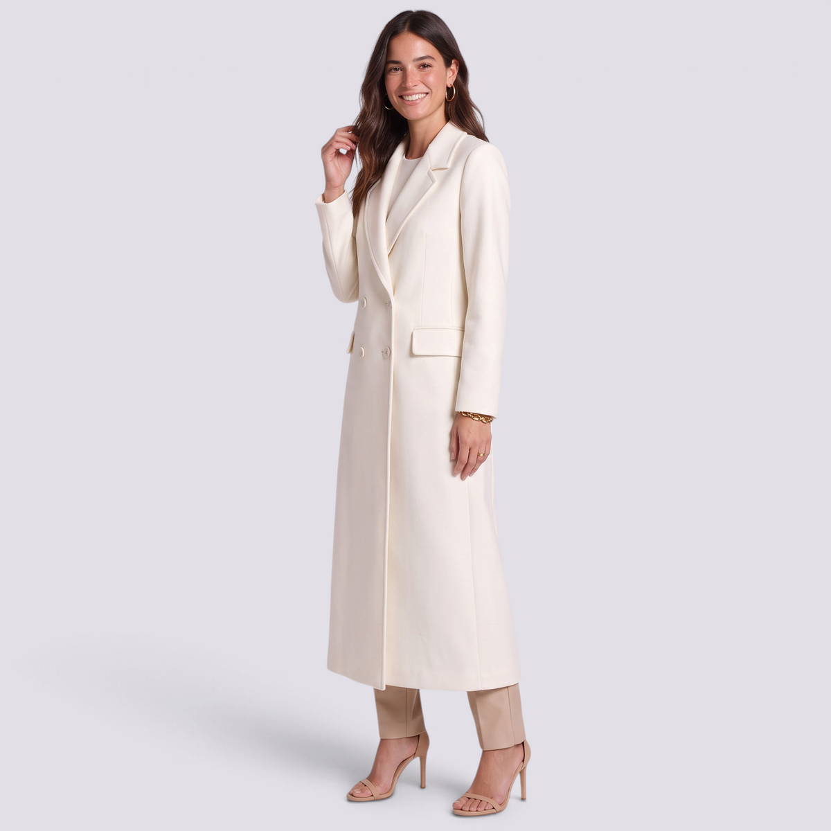 Essyro long cream coat with wide lapels and button closure worn by a smiling woman in a studio setting