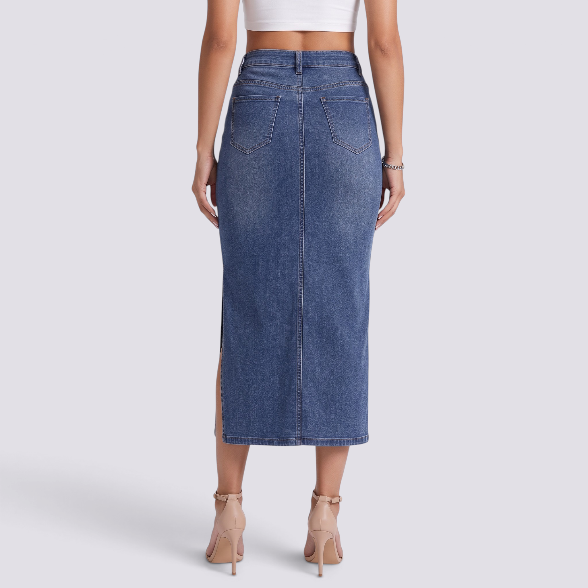 Essyro long fitted denim skirt in vintage wash blue with a side slit, worn by a model from the back view.