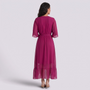 Essyro magenta maxi dress with batwing sleeves, cinched waist, and asymmetrical hem viewed from the back