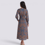 Back view of an Essyro midi A-line dress with 3/4 sleeves and a blue and brown artistic floral print