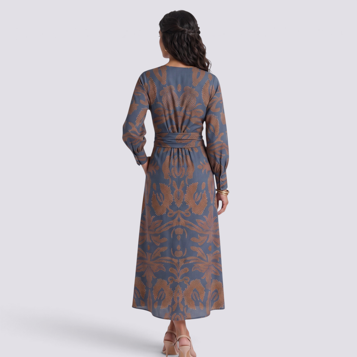 Back view of an Essyro midi A-line dress with 3/4 sleeves and a blue and brown artistic floral print