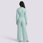 Back view of a woman wearing an Essyro mint green two-piece set with a cropped blazer and high-waisted palazzo pants.