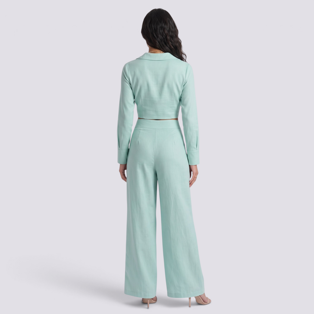 Back view of a woman wearing an Essyro mint green two-piece set with a cropped blazer and high-waisted palazzo pants.