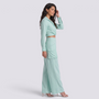 Essyro mint green two-piece set featuring a long-sleeve wrap top and high-waisted palazzo pants on a model