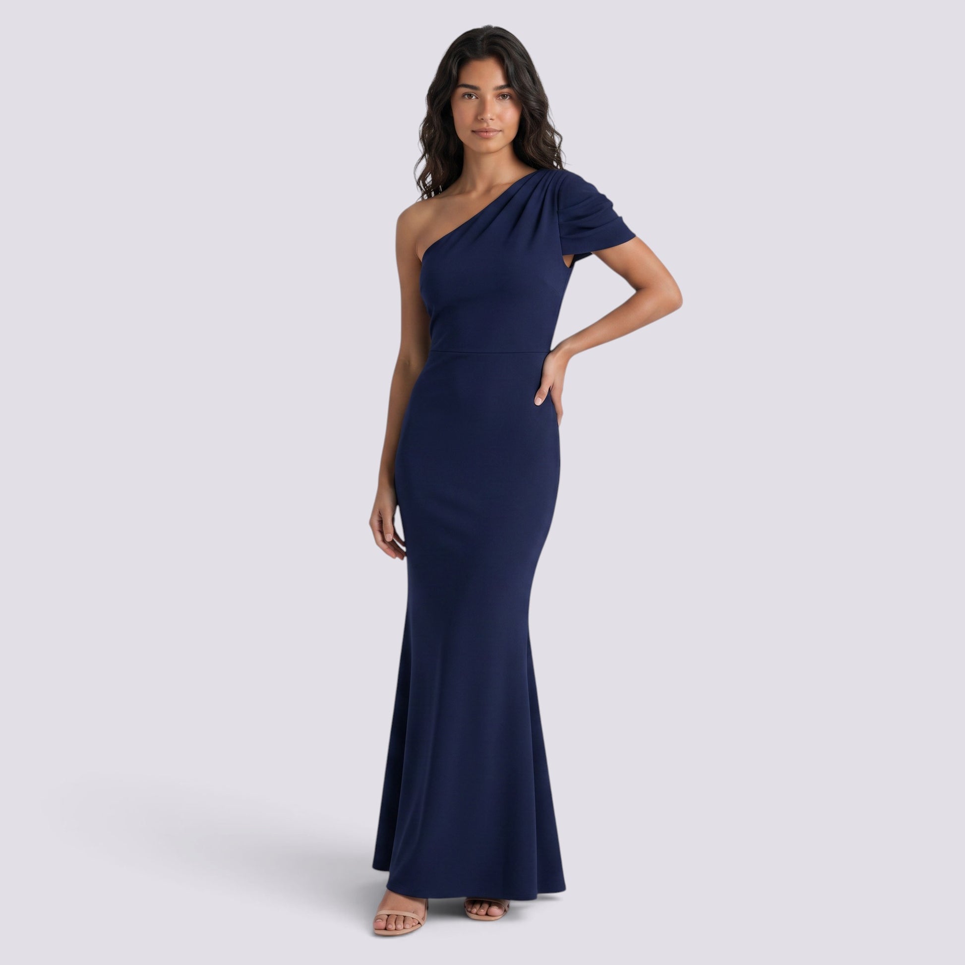Essyro navy blue floor-length mermaid gown with an asymmetrical one-shoulder neckline and draped sleeve detail.