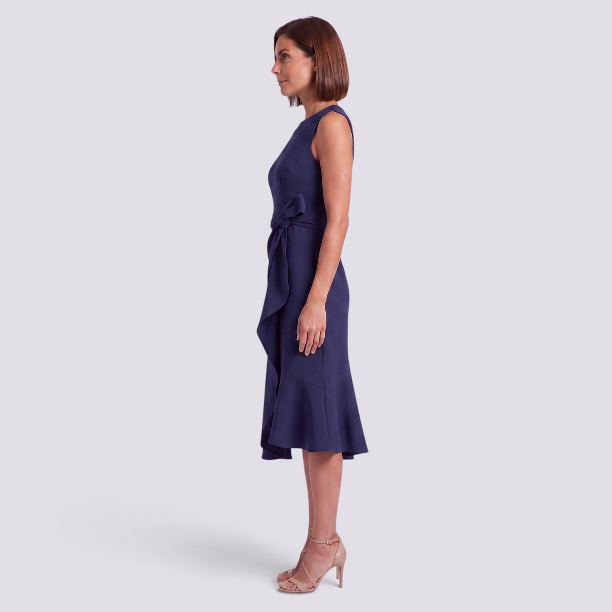 Essyro navy blue sleeveless midi dress with a round neckline and decorative waist bow, side view on a model