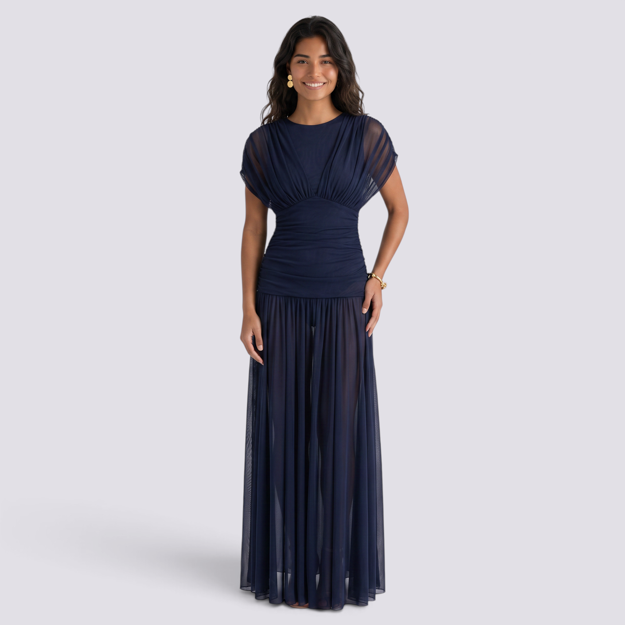 Essyro navy blue floor-length gown with a draped bodice and sheer pleated skirt worn by a smiling model
