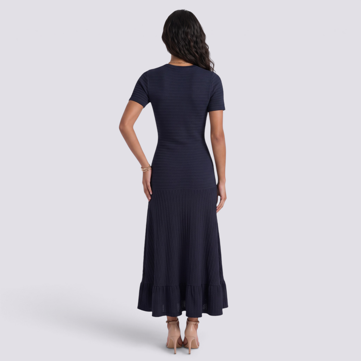 Essyro navy blue ribbed knit maxi dress with short sleeves and ruffled hem seen from the back on a model
