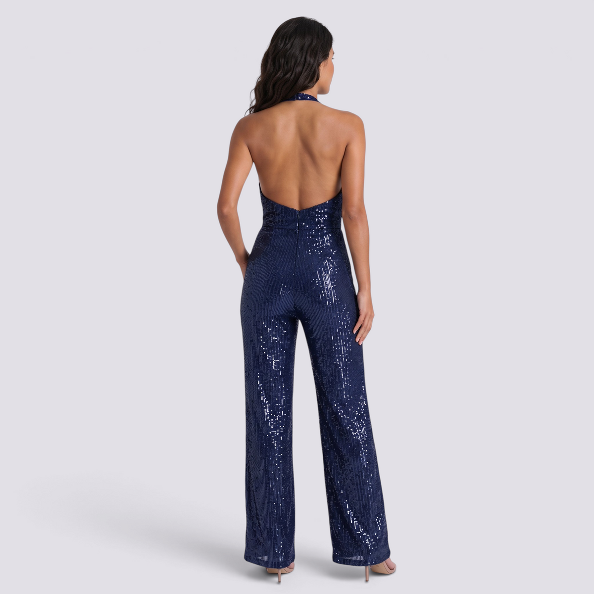 Essyro navy blue sequin jumpsuit with a halter neck, open back, and wide-leg trousers on a model, back view.