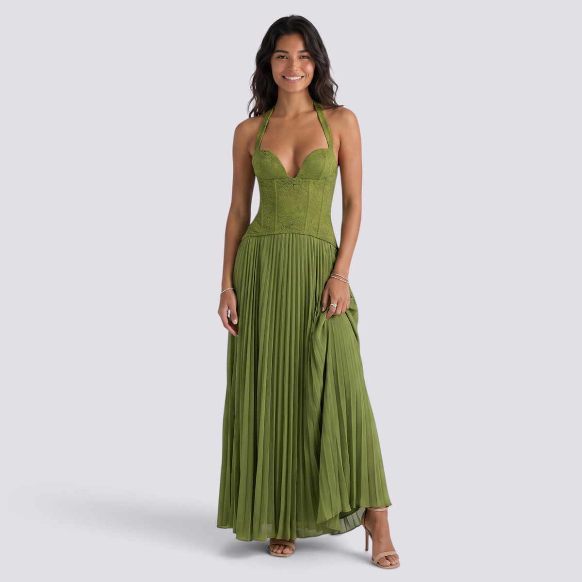 Essyro olive green floor-length pleated gown with a corset bodice, halter neckline, and open back on a smiling model