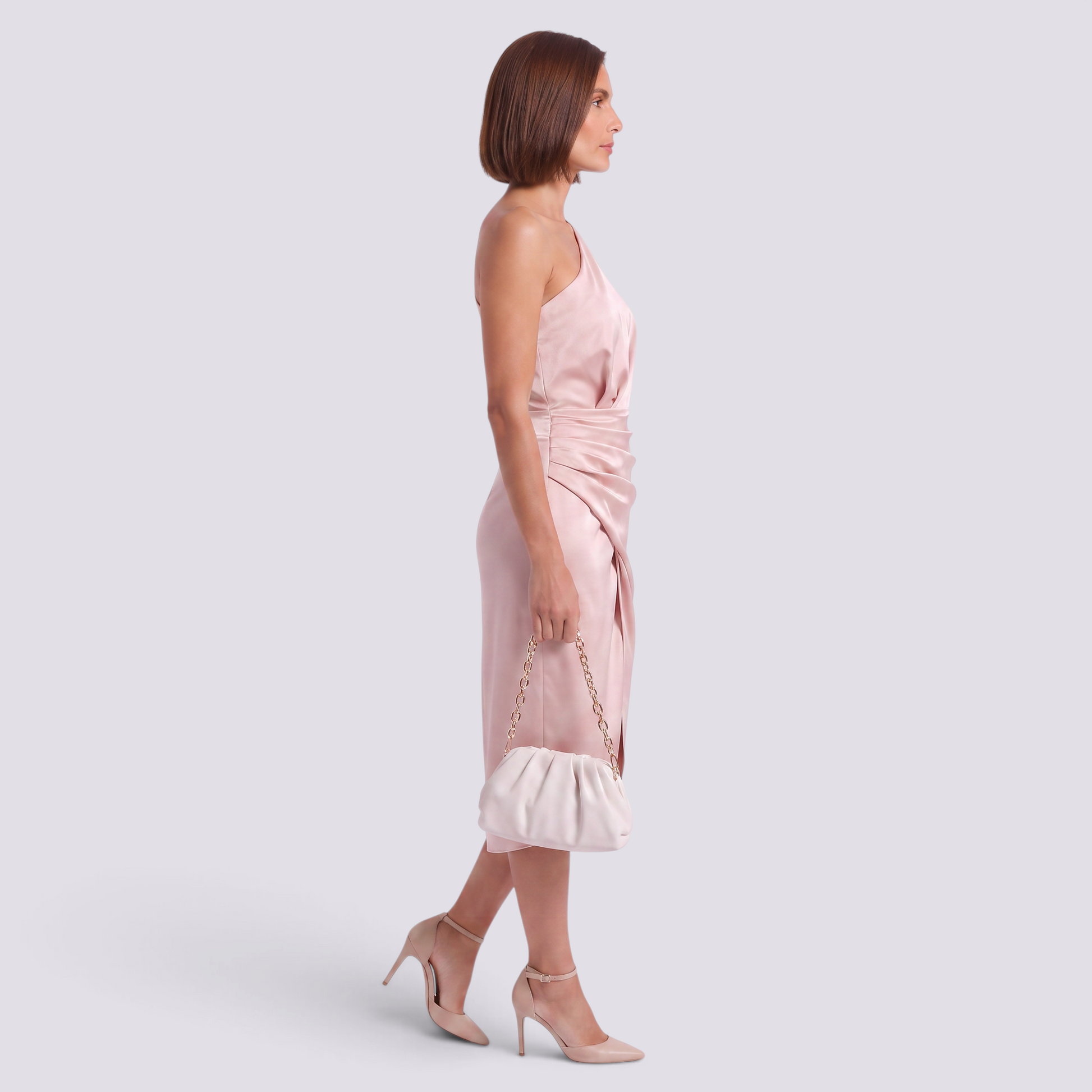 Essyro one-shoulder blush pink midi dress with asymmetric hem and ruched waist worn by a woman with heels and clutch