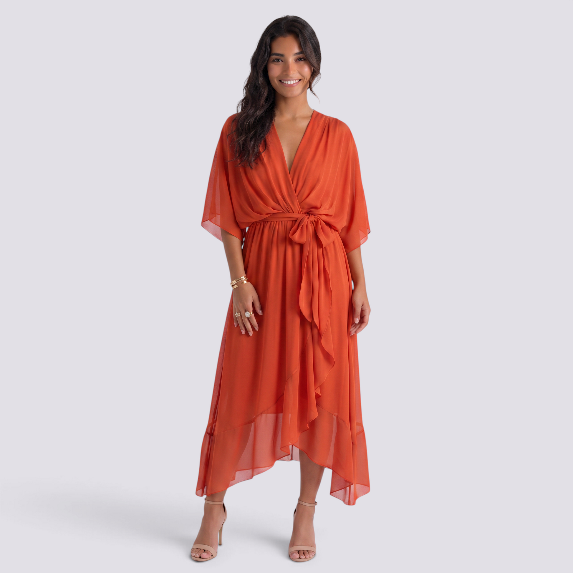 Essyro orange maxi dress with V-neck, batwing sleeves, and a tie-waist, worn by a smiling woman in heels.