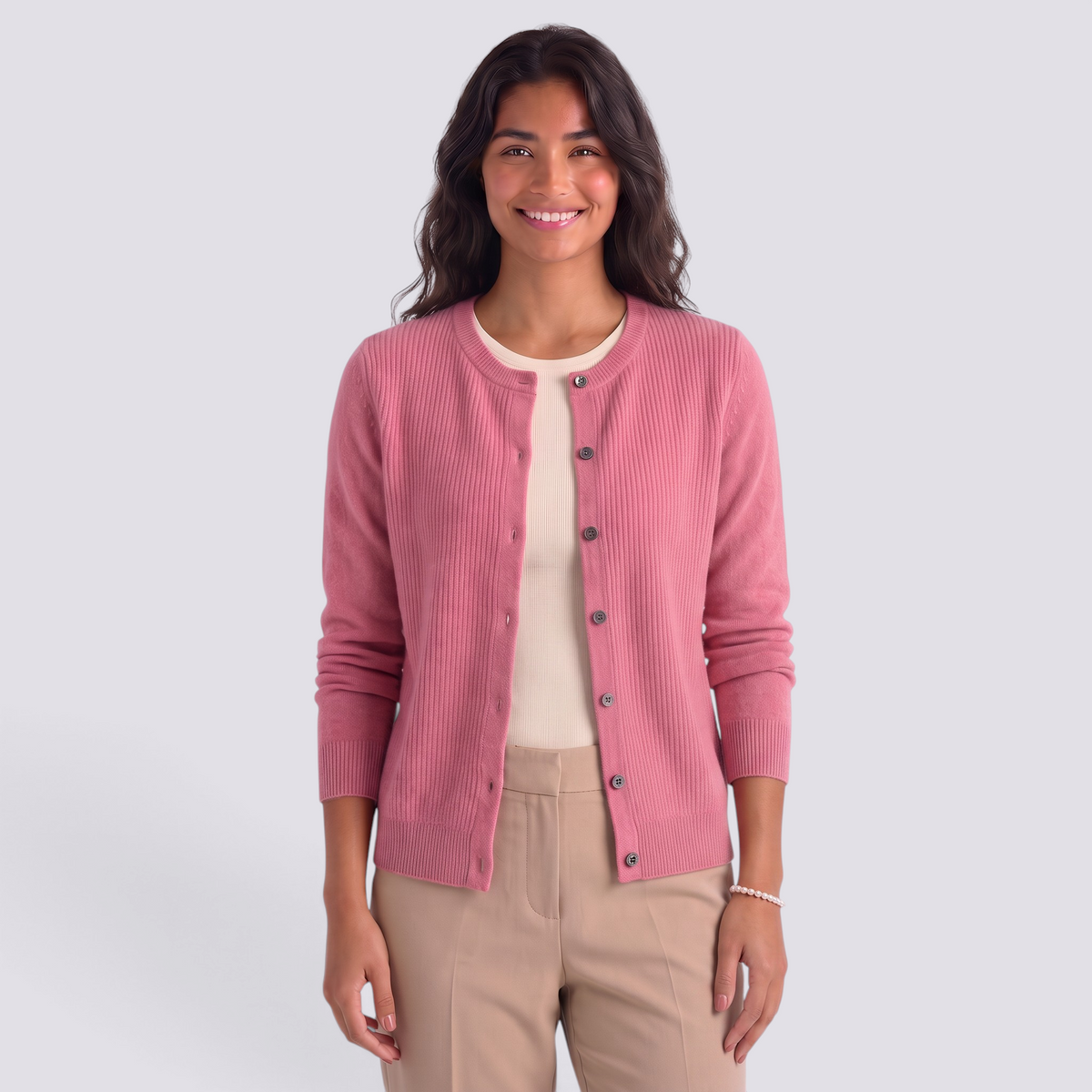 Essyro pink wool cardigan with a round neck and button-down front worn by a smiling woman on a neutral background.