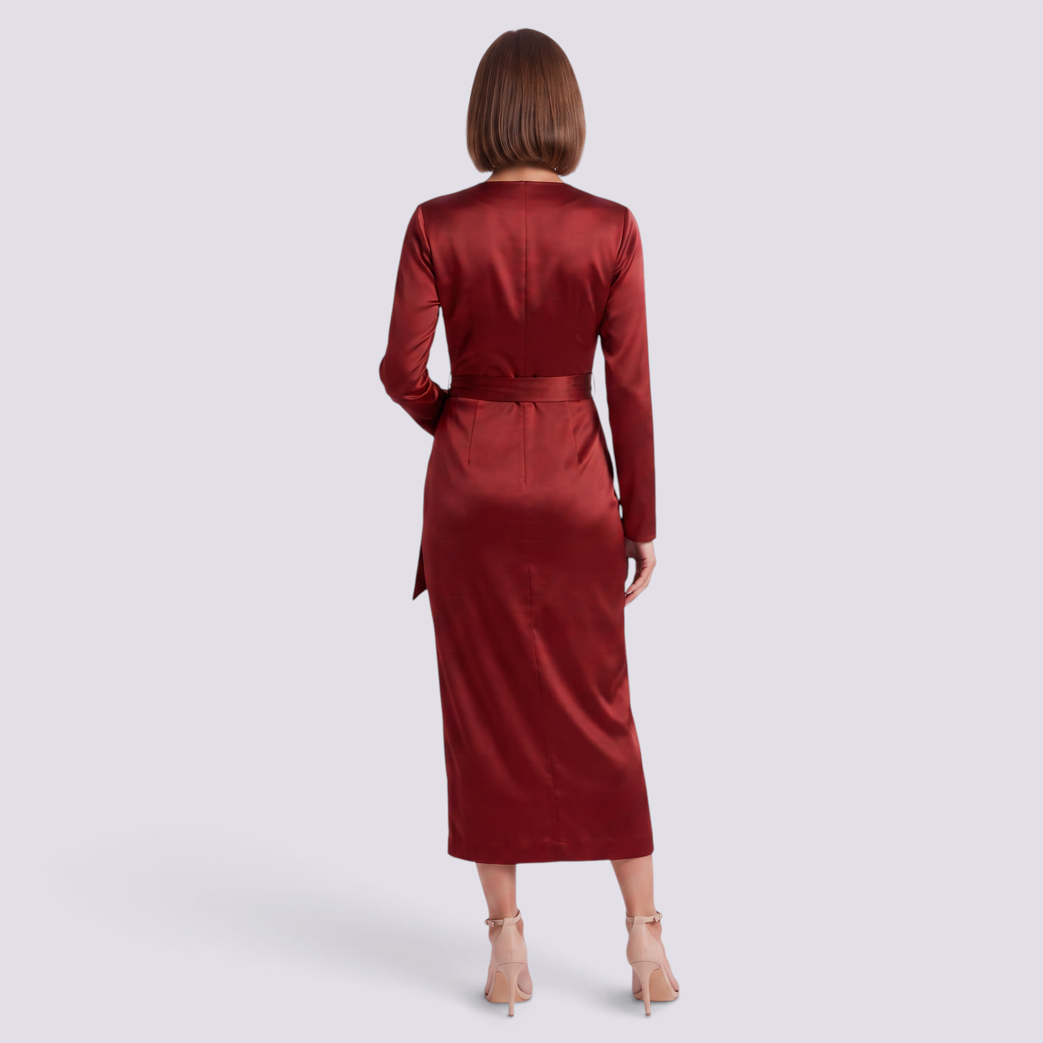 Back view of a woman wearing an Essyro long-sleeve midi dress in deep red satin with a waist tie, studio shot.