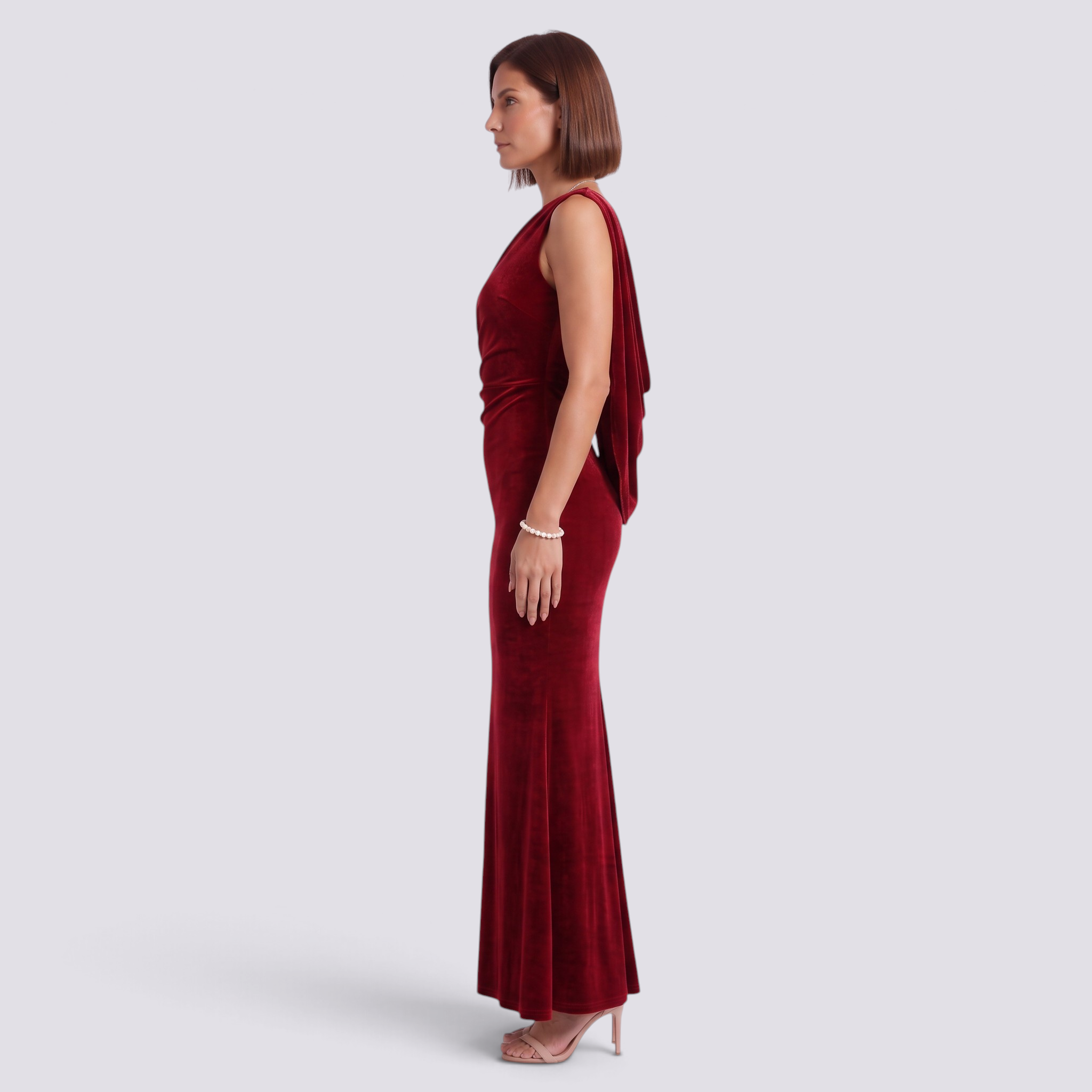 Essyro red velvet mermaid gown with an asymmetric one-shoulder neckline and flowing drape, worn by a model.