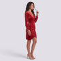 Essyro red velvet party dress with sequins, V-neck, long sleeves, and draped waist worn by a model in heels