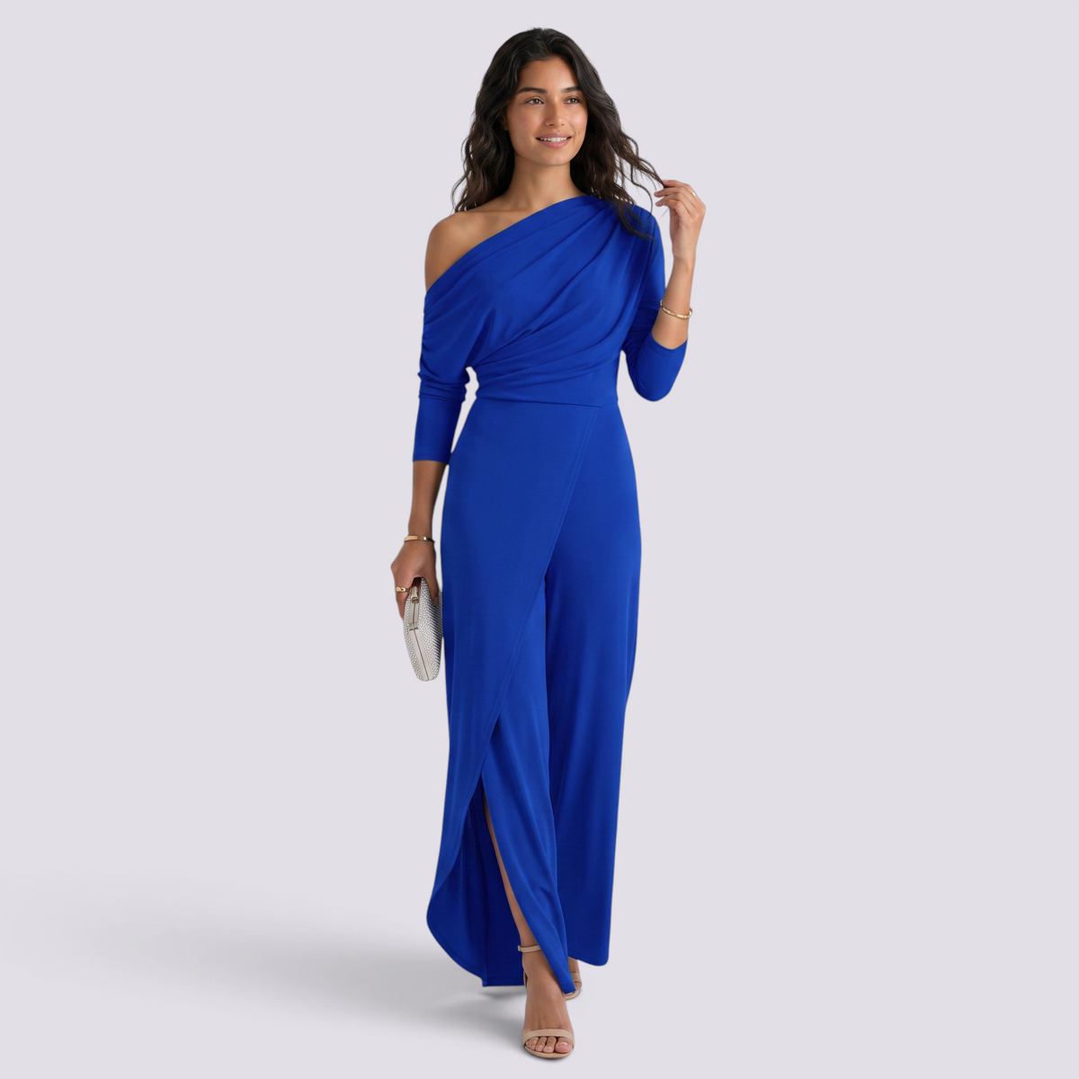Essyro royal blue one-shoulder jumpsuit with draped long sleeve and wide-leg trousers featuring a front slit.