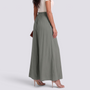 Essyro sage green wide-leg palazzo pants with paperbag elastic waist and drawstring, worn with beige heels.