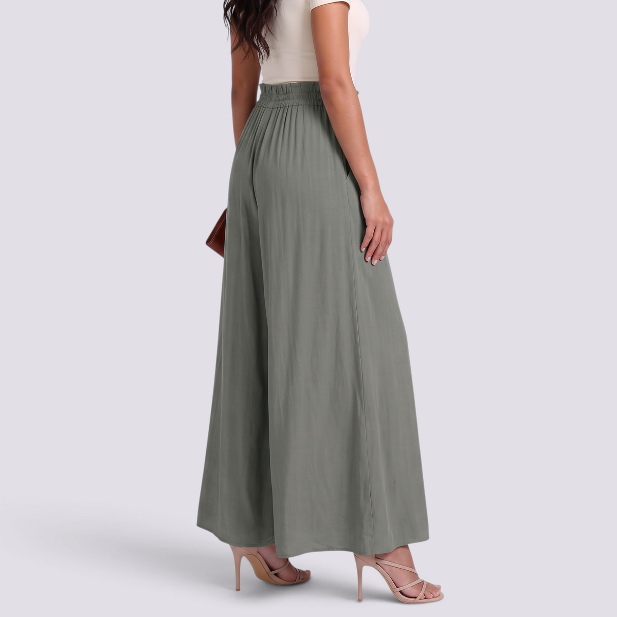Essyro sage green wide-leg palazzo pants with paperbag elastic waist and drawstring, worn with beige heels.
