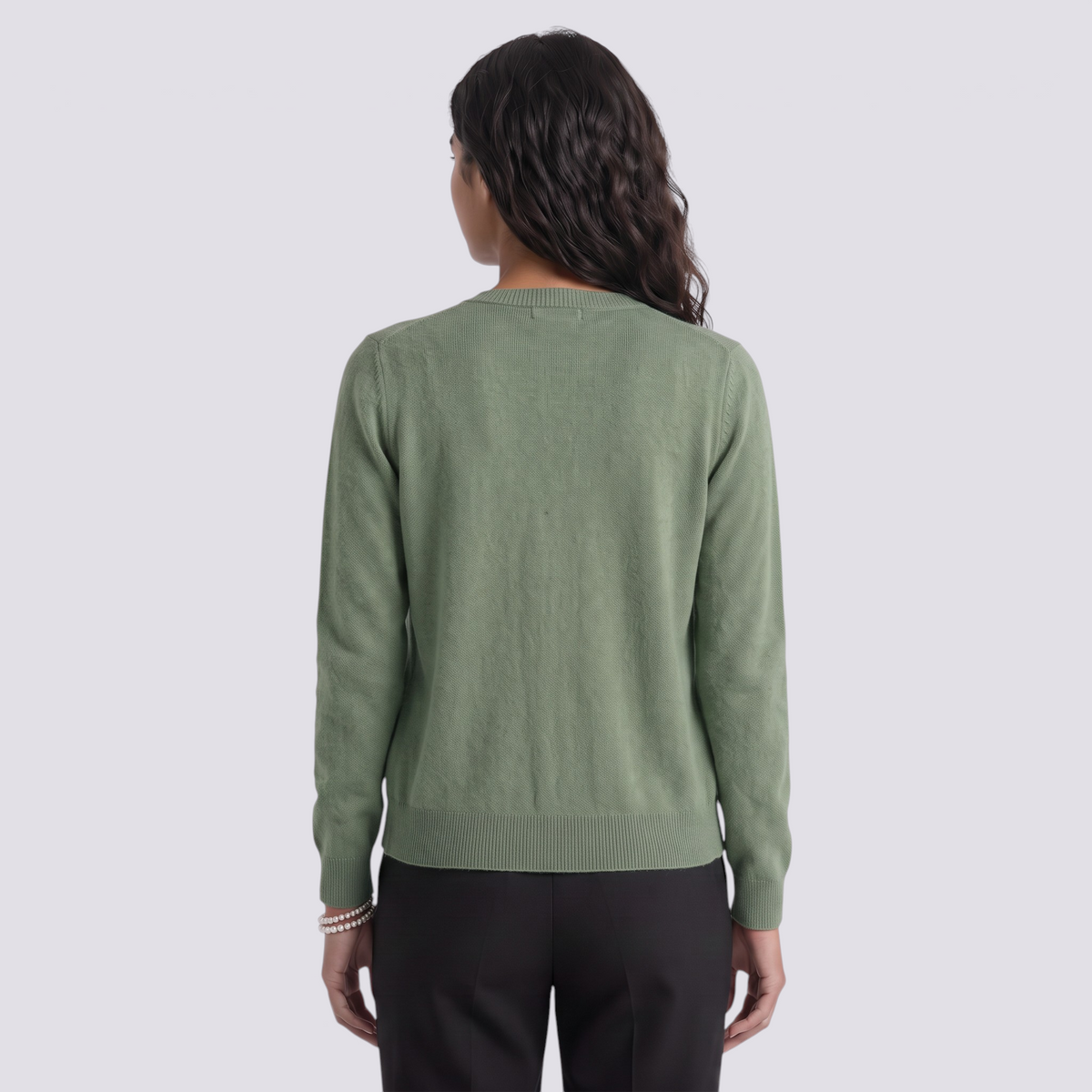 Essyro sage green wool cardigan with round neck and ribbed hem, back view on a model wearing black trousers.