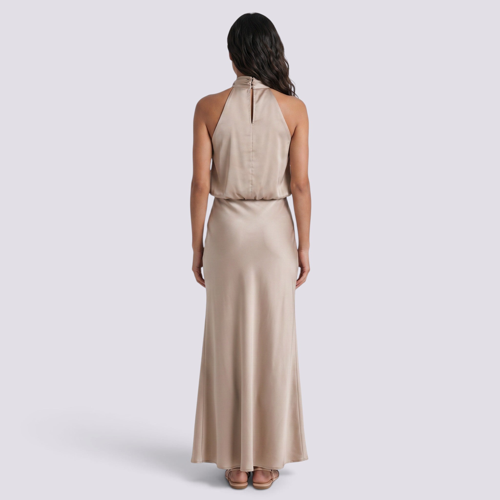 Back view of an Essyro satin halter neck maxi dress in champagne, featuring a draped neckline and fluid skirt.