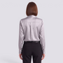 Back view of a woman wearing an Essyro long-sleeve silver satin shirt tucked into black trousers