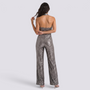 Essyro back view of a silver sequin halter neck jumpsuit with wide legs and an open back on a model